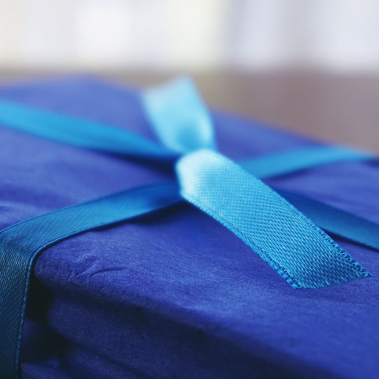 A blue gift box with a satin ribbon, perfect for celebrations